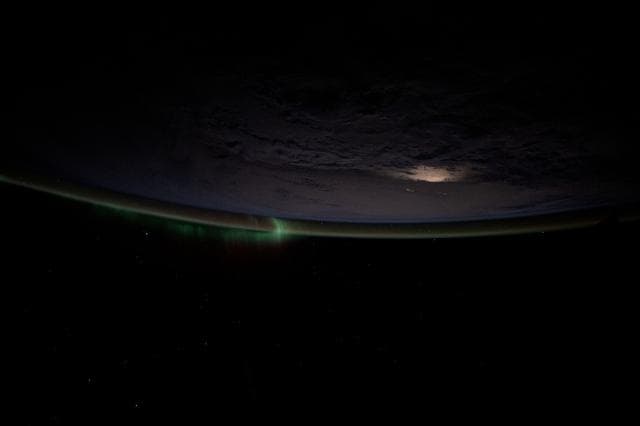 NASA image: A wispy aurora intersects with Earth's atmospheric glow