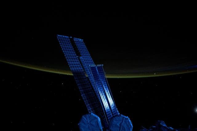 NASA image: Moonlight casts a blue light on a set of the space station's main solar arrays and rollout solar arrays