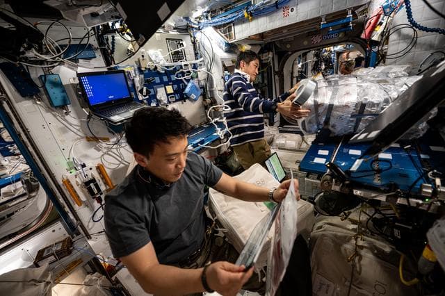 NASA image: Astronauts Jonny Kim and Takuya gathers cargo to be packed inside the SpaceX Dragon cargo spacecraft