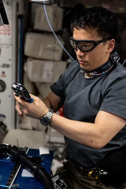 NASA image: NASA astronaut Jonny Kim wears goggles while working on computer network maintenance