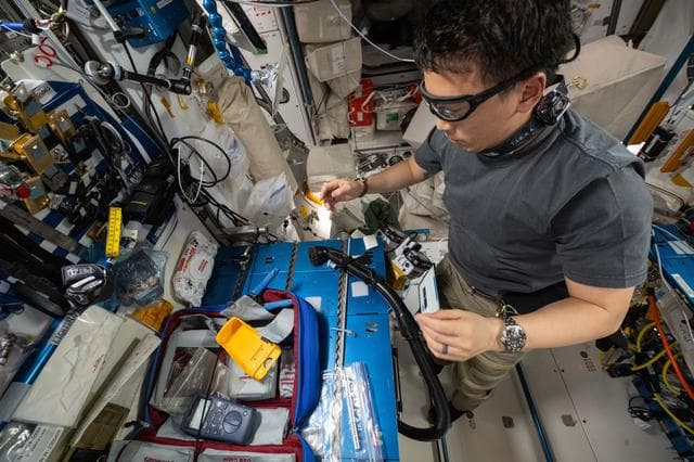 NASA image: NASA astronaut Jonny Kim repairs ethernet cables aboard the International Space Station