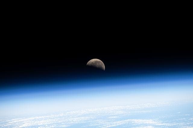 NASA image: The last Quarter Moon is pictured above Earth's atmosphere