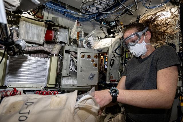 NASA image: NASA astronaut Nichole Ayers works on an experimental carbon dioxide removal device