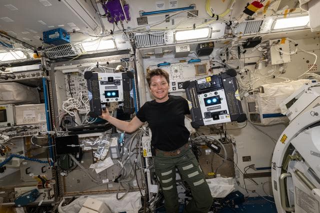 NASA image: Astronaut Anne McClain shows off a pair of Astrobee robotic free-flyers