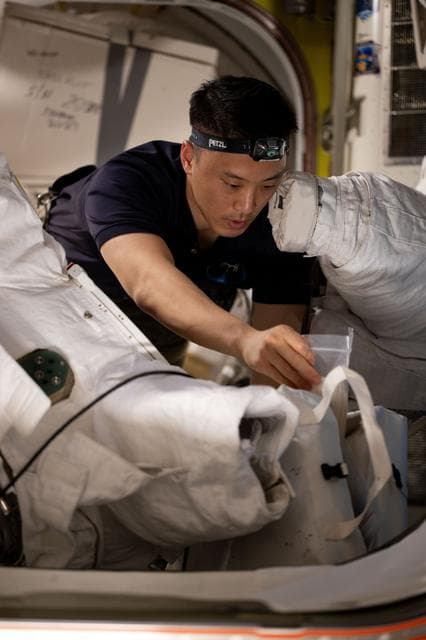 NASA image: NASA astronaut Jonny Kim works on spacesuit maintenance operations