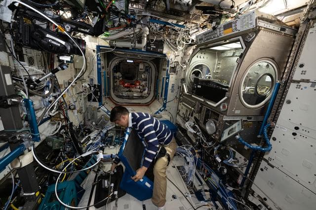 NASA image: JAXA astronaut Takuya Onishi stows physics research hardware used during the Colloidal Solids experiment