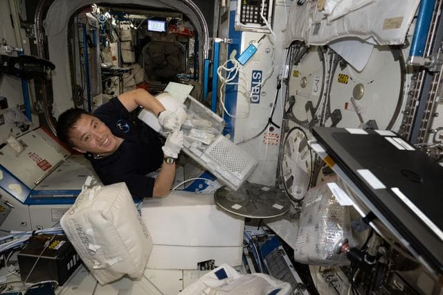 NASA image: NASA astronaut Jonny Kim stows research samples inside a cryogenic storage unit