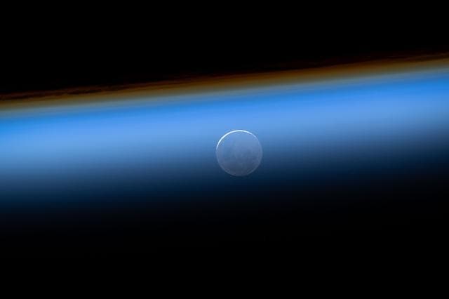 NASA image: The New Moon is pictured seemingly beneath Earth's atmosphere
