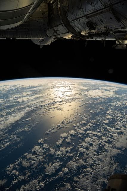 NASA image: The sun's glint beams off a partly cloudy southern Pacific Ocean