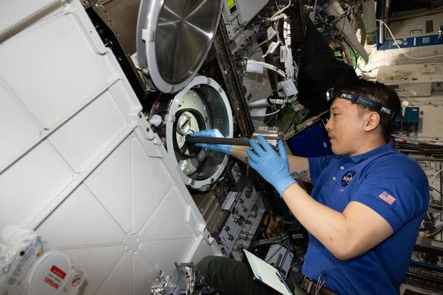 NASA image: NASA astronaut Jonny Kim removes research hardware from inside the Materials Science Laboratory