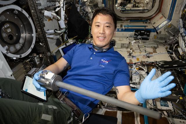 NASA image: NASA astronaut Jonny Kim waves for a portrait while removing research hardware
