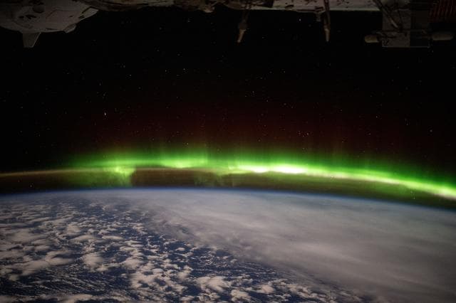 NASA image: A bright green aurora australis streams above Earth's horizon