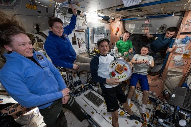 NASA image: JAXA astronaut Takuya Onishi shows off a hamburger-shaped cake