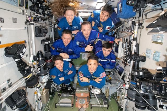 The seven-member Expedition 73 crew poses for a portrait
