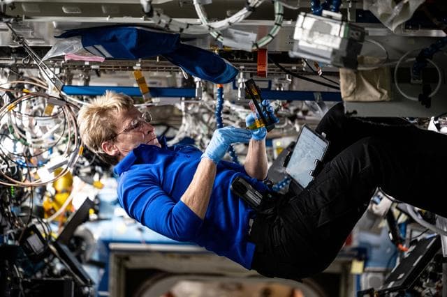 NASA image: Axiom Mission 4 Commander Peggy Whitson configures research hardware