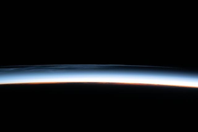 NASA image: Noctilucent clouds are pictured above the North Pacific Ocean