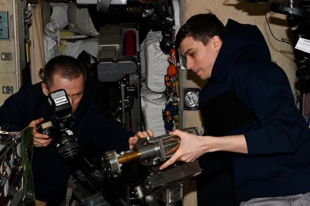 NASA image: Roscosmos cosmonauts Sergey Ryzhikov and Alexey Zubritsky inspect treadmill components 