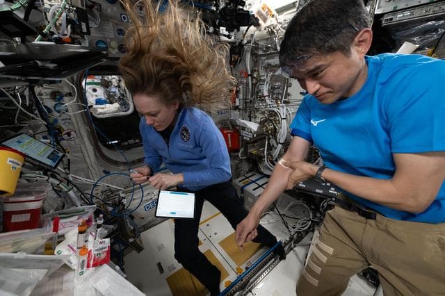 NASA image: Astronauts Nichole Ayers and Takuya Onishi collect blood samples