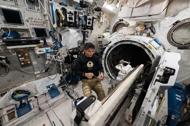 NASA image: JAXA astronaut Takuya Onishi removes research hardware attached to the airlock slide table