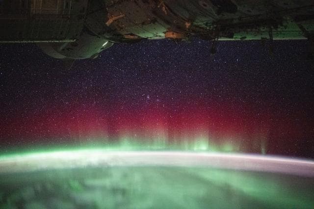 NASA image: A vivid red and green aurora crowns Earth’s horizon