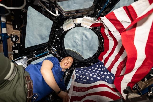 NASA image: NASA astronaut Jonnny Kim poses for a portrait with the American flag on the Fourth of July