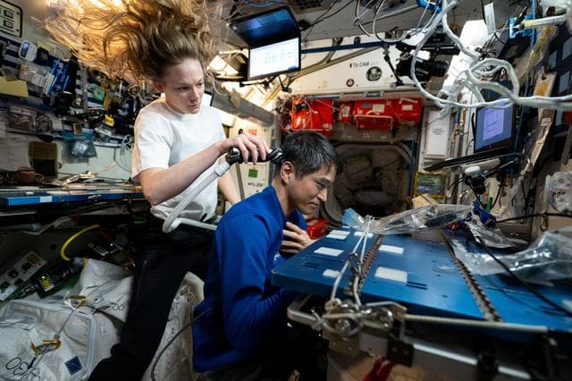 Nichole Ayers trims Takuya Onishi's hair aboard the International Space Station