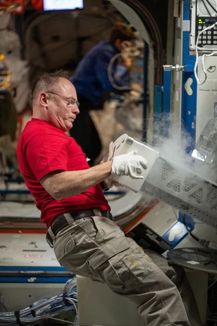 NASA image: NASA astronaut Mike Fincke inserts research samples into a science freezer 