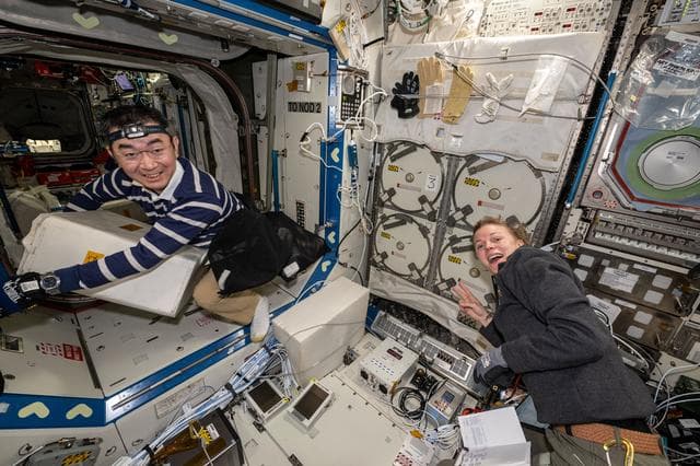 NASA image: Astronauts Kimiya Yui and Zena Cardman unpack science, supplies, and hardware