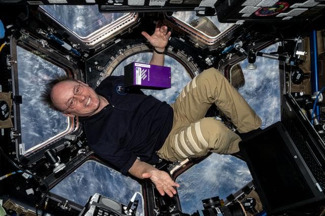 NASA image:  NASA astronaut Mike Fincke displays protein crystal research hardware