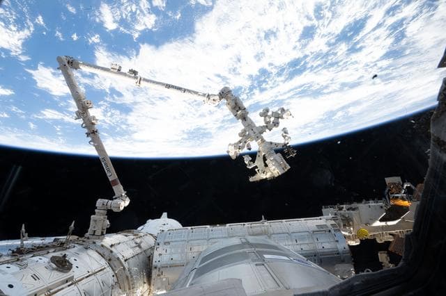 NASA image: The Canadarm2 robotic arm extends from a data grapple fixture on the International Space Station
