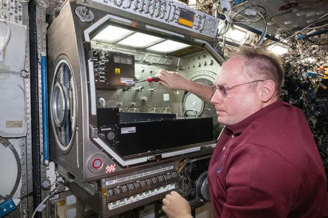 NASA image: NASA astronaut Mike Fincke sets up the Colloidal Solids research hardware