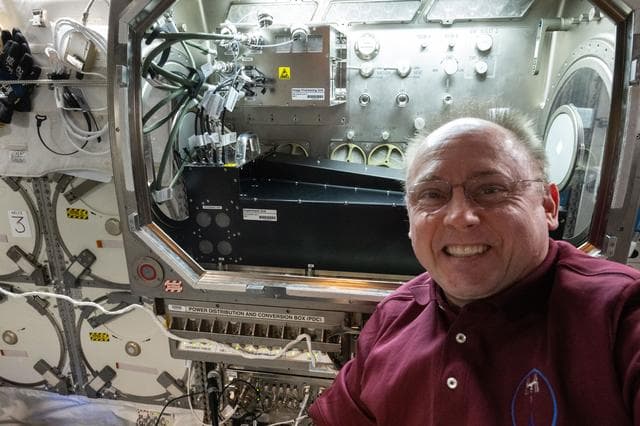 NASA image: NASA astronaut Mike Fincke poses for a portrait in front of the Microgravity Science Glovebox