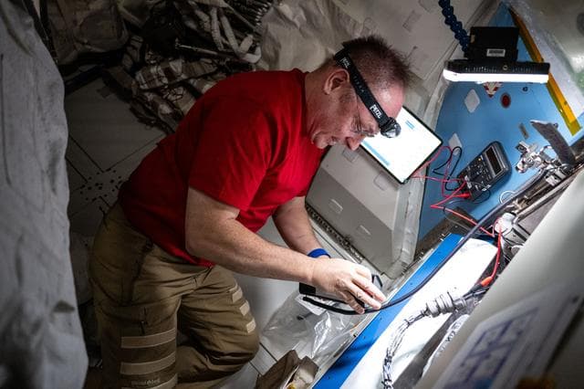 NASA image: NASA astronaut performs electrical resistance measurements on the thermal control system 