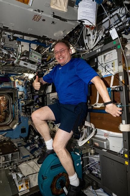 NASA image:  NASA astronaut pedals on the International Space Station's exercise cycle