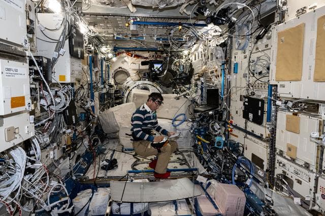 NASA image: JAXA astronaut Kimiya Yui takes notes while installing new computer networking gear