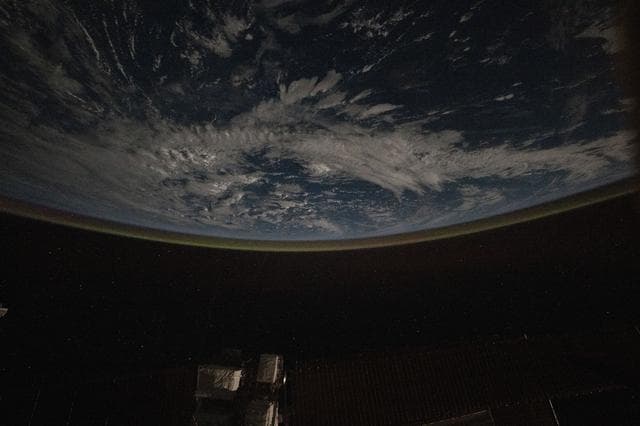 NASA image: A faint airglow blankets Earth's horizon above the Pacific Ocean