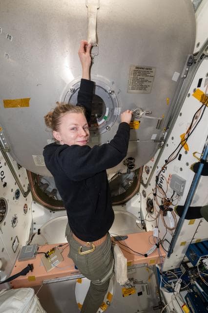 NASA astronaut Zena Cardman opens the hatch to the Cygnus XL cargo craft