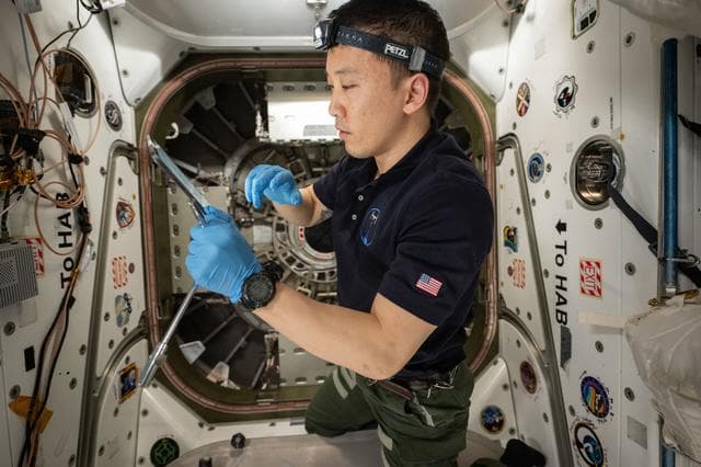NASA astronaut Jonny Kim reviews Cygnus XL procedures on a computer tablet