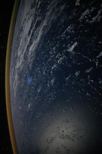 NASA image:  A red-yellow airglow blankets Earth's horizon above the Philippine Sea