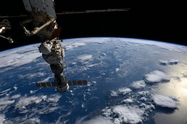 NASA image: The Soyuz MS-27 crew spacecraft  above a gleaming blue Atlantic Ocean