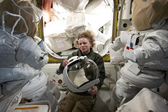 NASA image: NASA astronaut Zena Cardman inspects a spacesuit helmet
