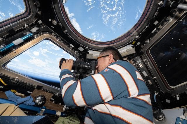 NASA image: JAXA astronaut Kimiya Yui points a camera out a cupola window and photographs station hardware