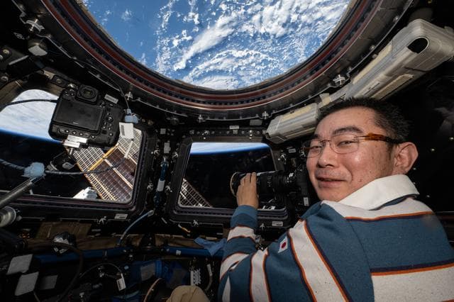 NASA image: JAXA astronaut Kimiya Yui points a camera out a cupola window and photographs station hardware