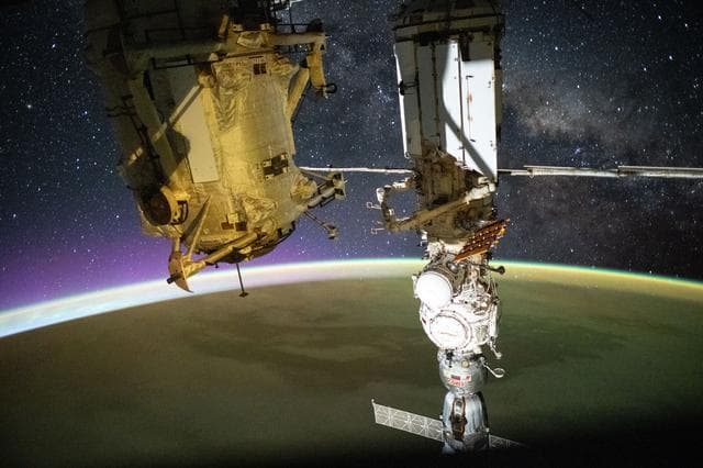 NASA image: A yellow-green airglow blankets Earth as an orbital sunrise illuminates the planet