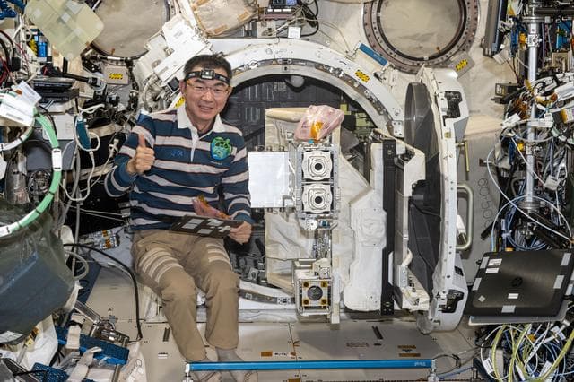 NASA image: JAXA astronaut Kimiya Yui removes a small satellite orbital deployer from the Kibo airlock 