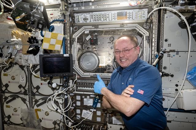 NASA image: NASA astronaut Mike Fincke gives a thumbs-up in front of the Microgravity Science Glovebox