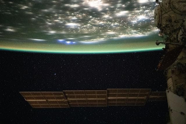 NASA image: A blue-green airglow blankets the bright city lights of the eastern United States
