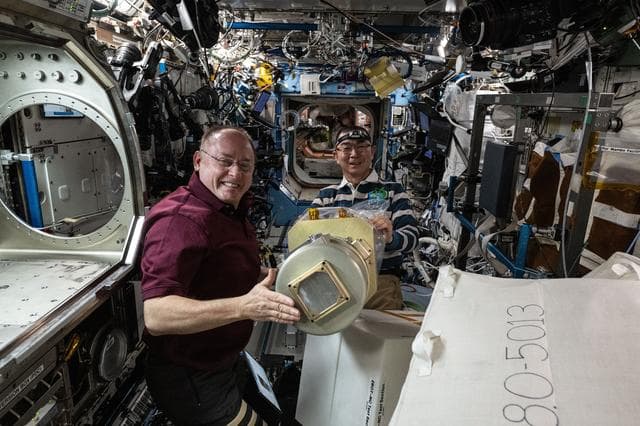 NASA image: Astronauts Mike Fincke and Kimiya Yui work together to configure research hardware