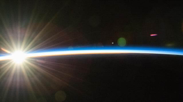 NASA image: An orbital sunrise bursts above Earth's horizon