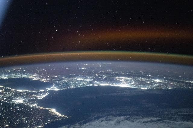 NASA image: A red-yellow airglow blankets Earth's horizon above southwestern Europe and North Africa